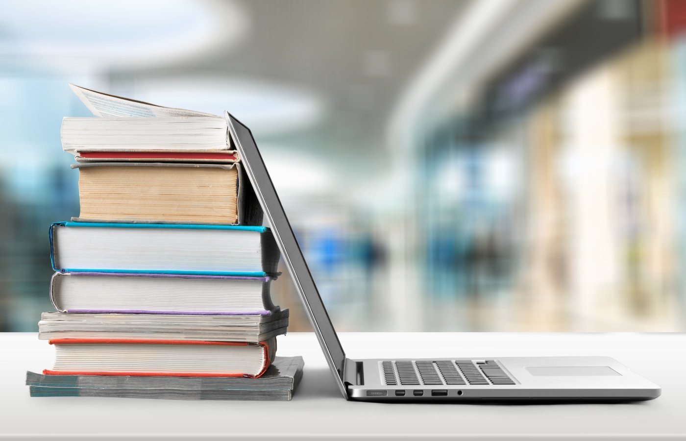 stack of books next to a computer