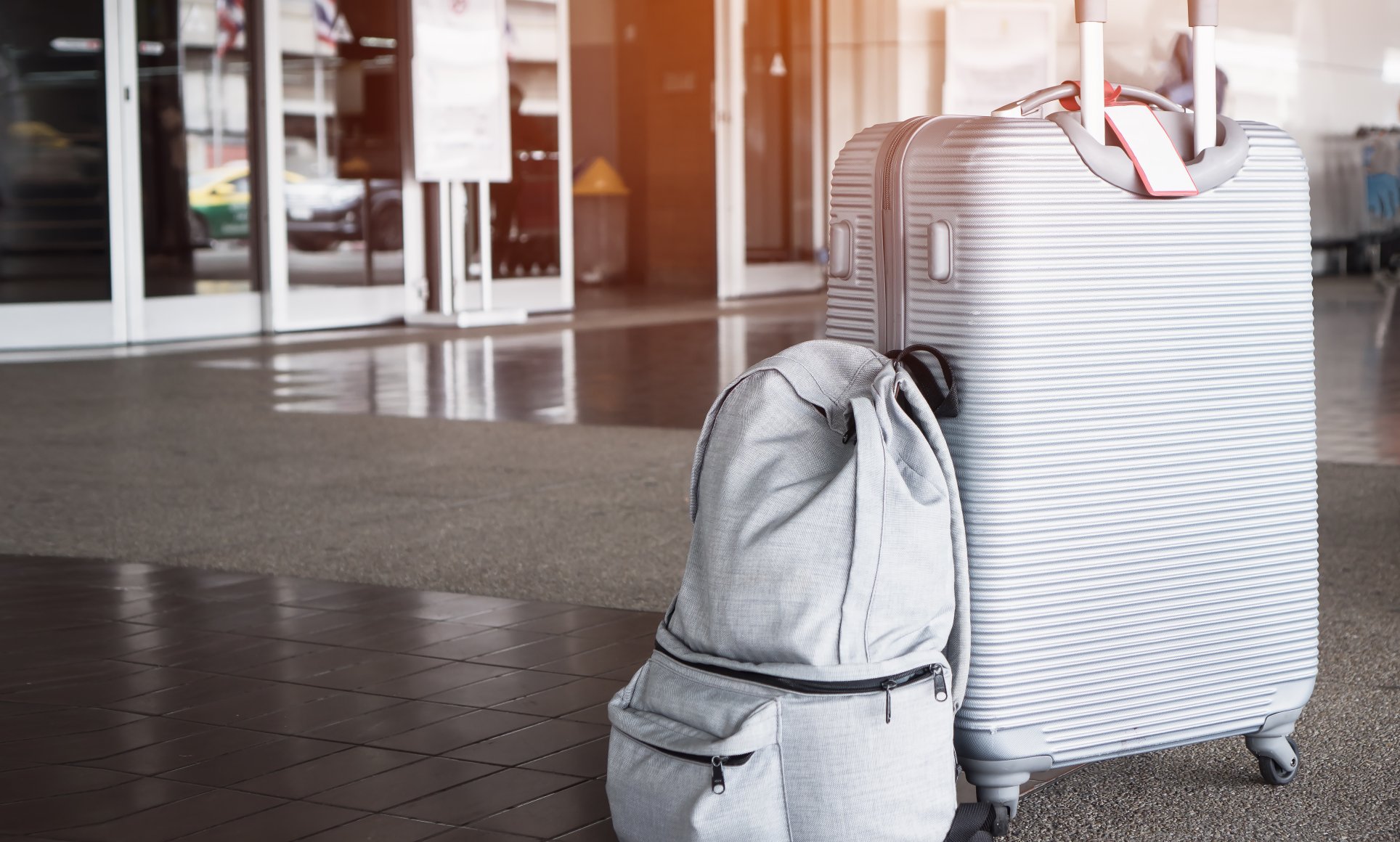 suitcase and backpack sitting outside a door