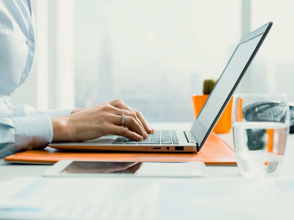 person with hands on laptop keyboard