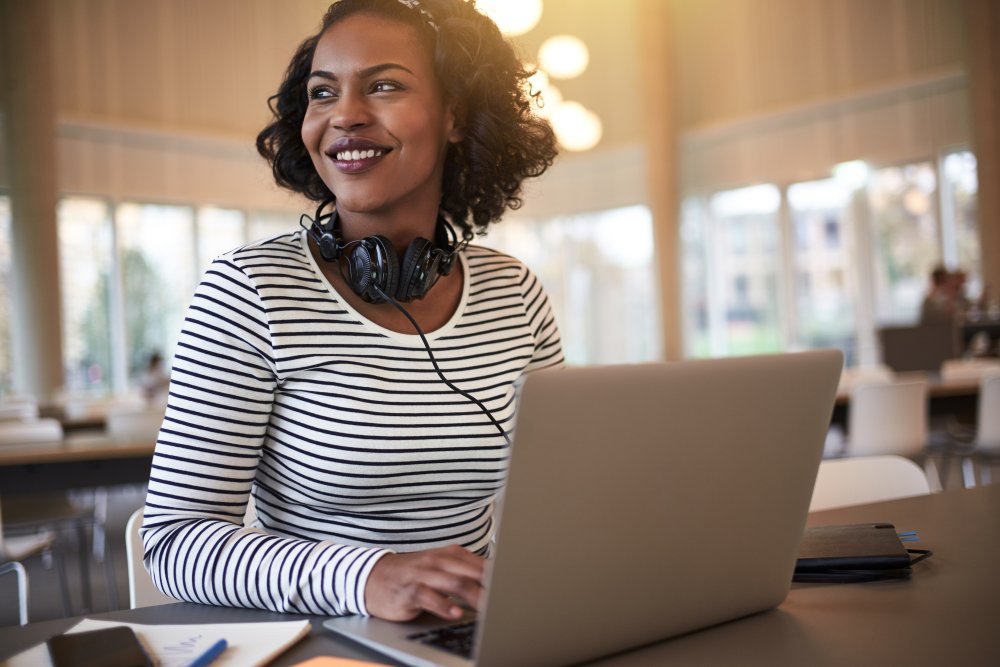 Young woman smiling while working at a laptop computer 